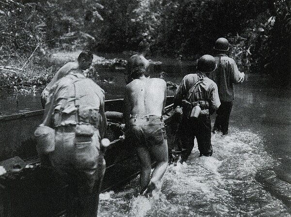 U.S. Army soldiers push supplies up the Matanikau River to support the 25th Infantry Division's offensive on Guadalcanal in January 1943.