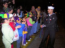 Mardi Gras in Galveston US Navy 060225-N-8374E-003 Seaman Recruit Zachary D. Lyons, assigned to the amphibious transport dock ship USS Trenton (LPD 14) gives beads to cheering spectators along the Krewe of Momus Mardi Gras parade route.jpg