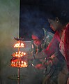 Women lighting earthen lamps on occasion of 2017 Sandhi puja at Manikanchan 24