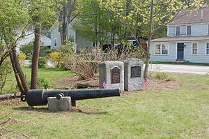 The Hartshorn Cannon and war memorials on the South Lyndeborough village common, April 2010. The blue house on the right is believed to have been J. Alonzo Hartshorn's family home. ---File---southlyndeboroughcommon.JPG