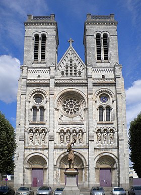 La façade de la basilique, sur la place des Enfants-Nantais, au centre de laquelle est érigée une statue équestre de Jeanne d'Arc signée Charles-Auguste Lebourg (1829-1906).