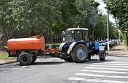A MTZ-82.1 tractor with street sprinkling equipment and a towed water tank. 2014.