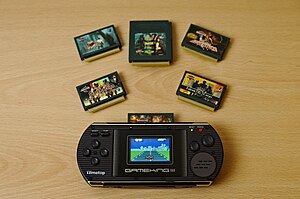 GameKing III handheld video game console with games, demonstrating its notable hexagonal screen GameKing III with games.jpg