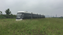 Bombardier Primove Tram traveling through Nanjing grassy field Hexi tram.png