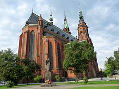 Foto tomada de la plaza Powstańców Wielkopolskiech, en primer plano hay un monumento a Juan Pablo II