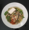 Mie cakalang, a noodle soup dish from Manado, Sulawesi Utara. It consists of noodles, shredded skipjack tuna meat, white tofu, slices of carrot and cucumber, mustard greens, scallion, and sambal.