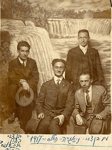 Ben Cvi stojí ve skupině mužů, na pozadí obraz vodopádu