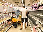 Empty shelves after panic buying at a FairPrice supermarket