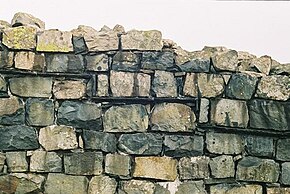 On many walls a slate layer demarcates original Roman construction (below) and modern reconstruction (above) Roman-damp-proof-course.jpg