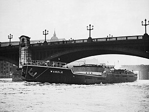 Wandle on her maiden voyage, 30 October 1932, on the Thames under Southwark Bridge. Her mast, funnel and wheelhouse are folded flat to pass under the bridge SS 'Wandle' (1932) under Southwark Bridge, London.jpg