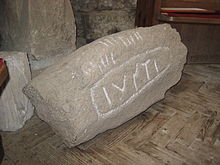 Granitstein in der Church of St James, St Kew; Latein- und Oghaminschrift (I)USTI (von links nach rechts) – 600 n. Chr.