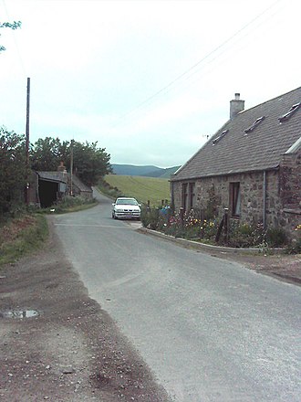 On the right the old Smithy at Backburn, now a private residence, farm buildings on the left The Smithy, Backburn.jpg