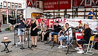 Bilder vom ZMF 2023: Die Gruppe two55 mit Alexander Heisler Querflöte:: Tiefe Stimmbänder & Chickeneggs - Fabian Funke:: Hohe Stimmbänder - Steffi Kromer ("Touching Vocals"/ "John Amann & The Legends")::Schwarze und weiße Tasten, Akkordeon & Gesang - Christian Moser und Sven von Thun::Hohe Saiten & Gesang - Dominik Leibold::Tiefe Saiten & Gesang - Jörg Hahn::Kessel, Becken, Kiste & Holzstöcke ("Godfather of two55") - Tobias Schulz