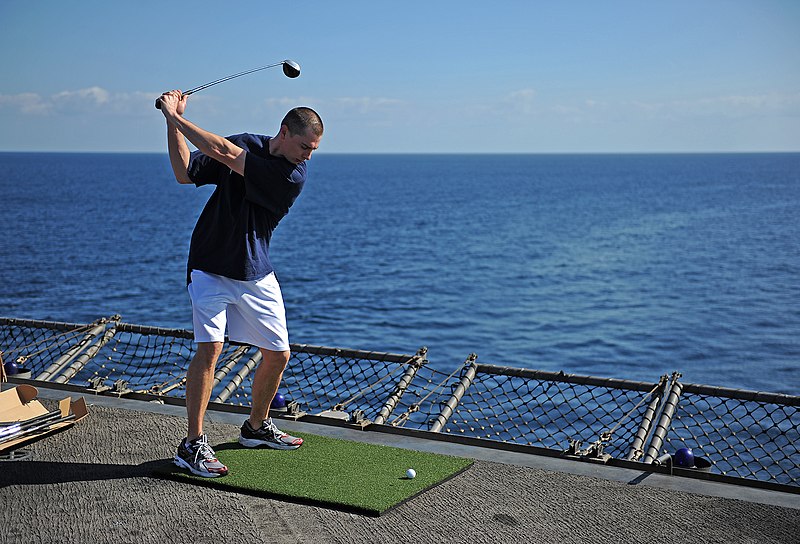 File:US Navy 120211-N-DX615-285 Interior Communications Electrician 1st Class Floyd Watson swings a gold club on the flight deck of the amphibious assau.jpg