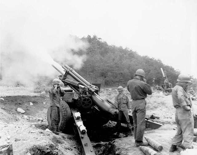 Firing of an M114 155 mm howitzer by the 90th Field Artillery Battalion, US 24th Infantry Division, during the Korean War