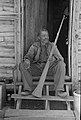 Old man born in slavery displays the horn formerly used to call slaves