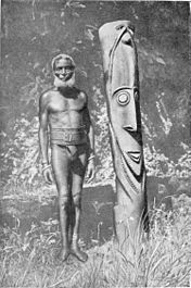 Een houtbewerker op Ambrym bij een zelfgemaakt godsbeeld rond 1920.