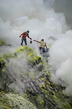 Mineração tradicional de enxofre no vulcão Ijen, Java Oriental, Indonésia. Esta imagem mostra as condições perigosas e difíceis que os mineiros enfrentam, incluindo a fumaça tóxica e quedas altas, bem como a falta de equipamentos de proteção. Os tubos sobre os quais estão colocados servem para guiar os vapores de enxofre e condensá-los, facilitando (bem, pelo menos relativamente) a produção. (definição 1 656 × 1 656)