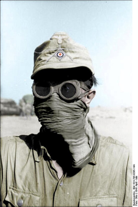 German infantryman seeking protection from desert dust: Western Desert: 1942.