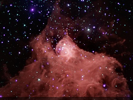 Young stars in and around molecular cloud Cepheus B. Radiation from one bright, massive star is destroying the cloud (from top to bottom in this image) while simultaneously triggering the formation of new stars.[18]