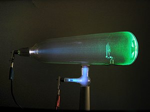 A glass tube containing a glowing green electron beam