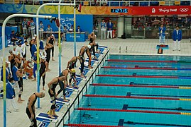 שחייה תחרותית: שחיינים נערכים להזנקת משחה 4×100 מטר (שליחים) חופשי לגברים באולימפיאדת הקיץ 2008 בבייג'ינג, סין. במסלול 4 עומד מייקל פלפס.