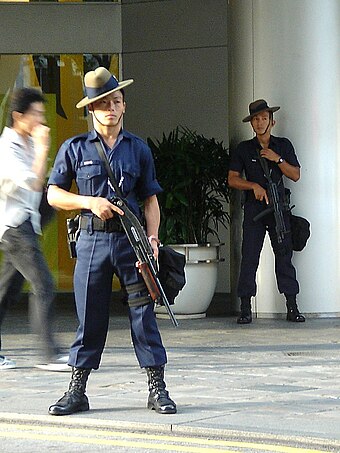 A Gurkha Contingent trooper in Singapore armed with a folding stock pump shotgun