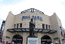 The limestone exterior of the park at the home plate entrance, with a statue of Honus Wagner Honus Wagner and PNC Park (3894720800).jpg