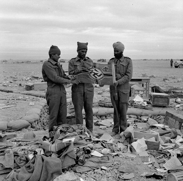Men of the 4th Indian Division with a captured German flag at Sidi Omar, Egypt.