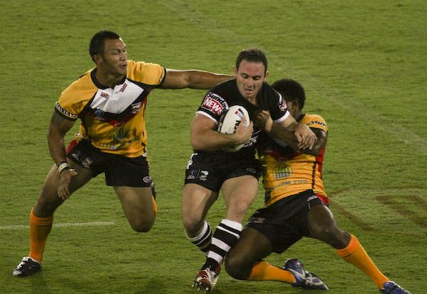 An attacking player attempts to evade two defenders.