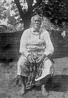 Photo en noir et blanc d'un homme à la moustache blanche.