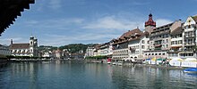 Blick von der Kapellbrücke auf die Reuss; rechts das Rathaus und links die Jesuitenkirche