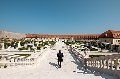 Man in a black suite walks down the Bratislava Castle garden staircase (Bratislava, Slovakia)