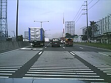 The North Luzon Expressway's raised plastic transverse rumble strips approaching Balintawak Toll Barrier, Philippines North Luzon Expressway Rumble Strips.jpg