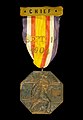 Médaille octogonale sur fond noir avec un ruban coloré