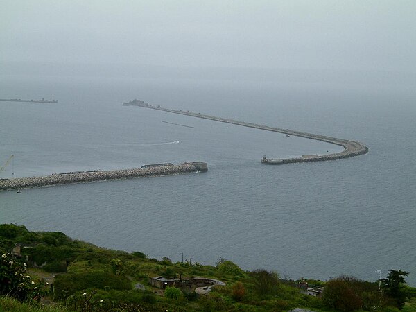 The outline of the wreck of Hood can be seen between the breakwaters of Portland Harbour.