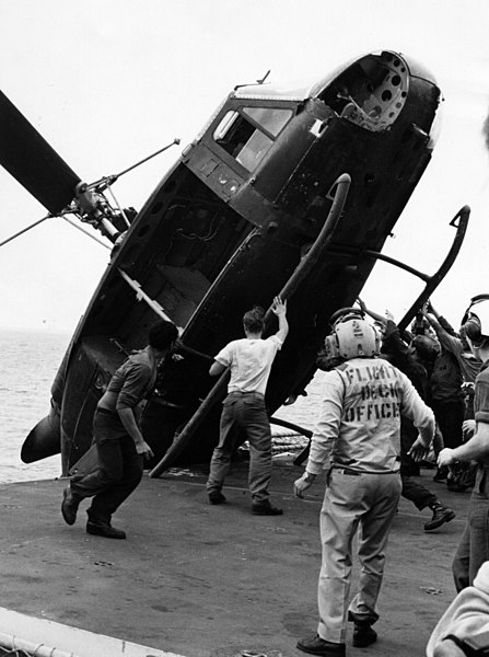 A South Vietnamese helicopter is pushed overboard from USS Okinawa to clear deck space for more incoming helicopters