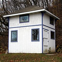 A tall shed with windows and a shingled roof TallShed.JPG