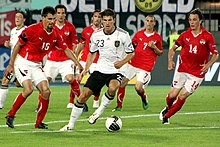 Gómez turns the ball away from five Austrian players as Mesut Özil runs in behind them
