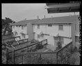 View of east end of south elevation of Building No. 20. Seen from balcony on west end of Building No. 30. Looking north - Easter Hill Village, Building No. 29, West side of Corto HABS CA-2783-V-5.tif
