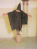 The Hooded Man being tortured at Abu Ghraib prison by U.S military