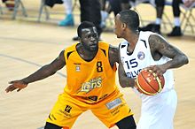 Owumi (right) is guarded by Joe Ikhinmwin of the London Lions in February 2014. Alex Owumi Worcester Wolves (2014).jpg