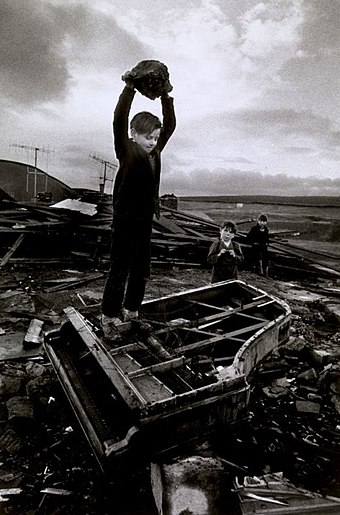 Boy destroying piano at Pant-y-Waen, South Wales, by Philip Jones Griffiths, 1961