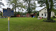 a picture of the marker with the house behind it