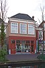 Winkelwonhuis, in oorsprong 17de-eeuws of ouder. Voorste gedeelte gemoderniseerd in de 18de eeuw en voorzien van een lijstgevel in Lodewijk XIV- vormen. Pui in 1920 ontworpen door E.H. Luxemburg.