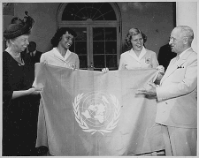 drie vrouwen en een man houden een vlag omhoog