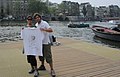 2009-06-27 #00384 Young couple on a ponton on the river Amstel in Amsterdam presents the white Free Travel-Shirt