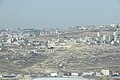 Below is the Shar Binyamin industrial zone. Behind on the right is an eastern edge of A-ram. Still behind is Tell-al-Full. Behind on the left is Neve Yaakov or Pisgat Zeev.