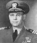 Kırklı yaşlarında gözlüklü ve II.Dünya Savaşı tarzı ABD deniz subayı üniforması giyen adamın başı ve omuzları