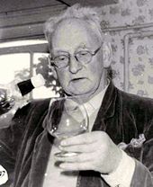 monochromatyczne zdjęcie mężczyzny w okularach i trzymającego kieliszek brandy
